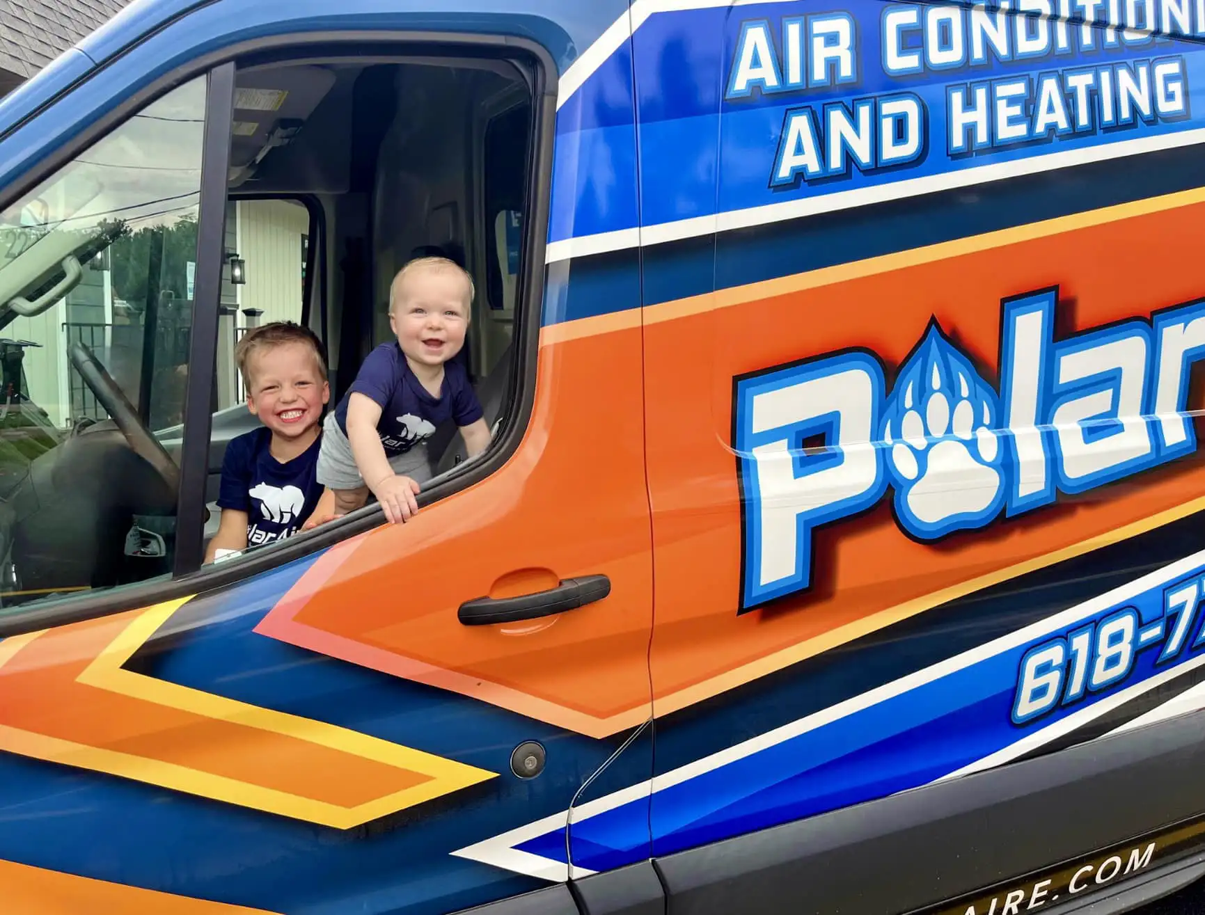 2 young kids smiling in polar aire van