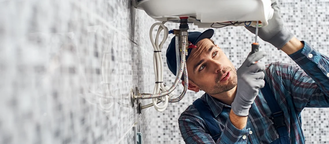 A male technician installs a new water heater in a home in O’Fallon, IL.